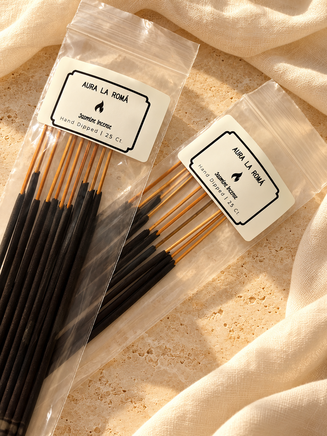 Aura La Roma hand-dipped incense in clear packaging with 25-count labels on warm stone and ivory linen.
