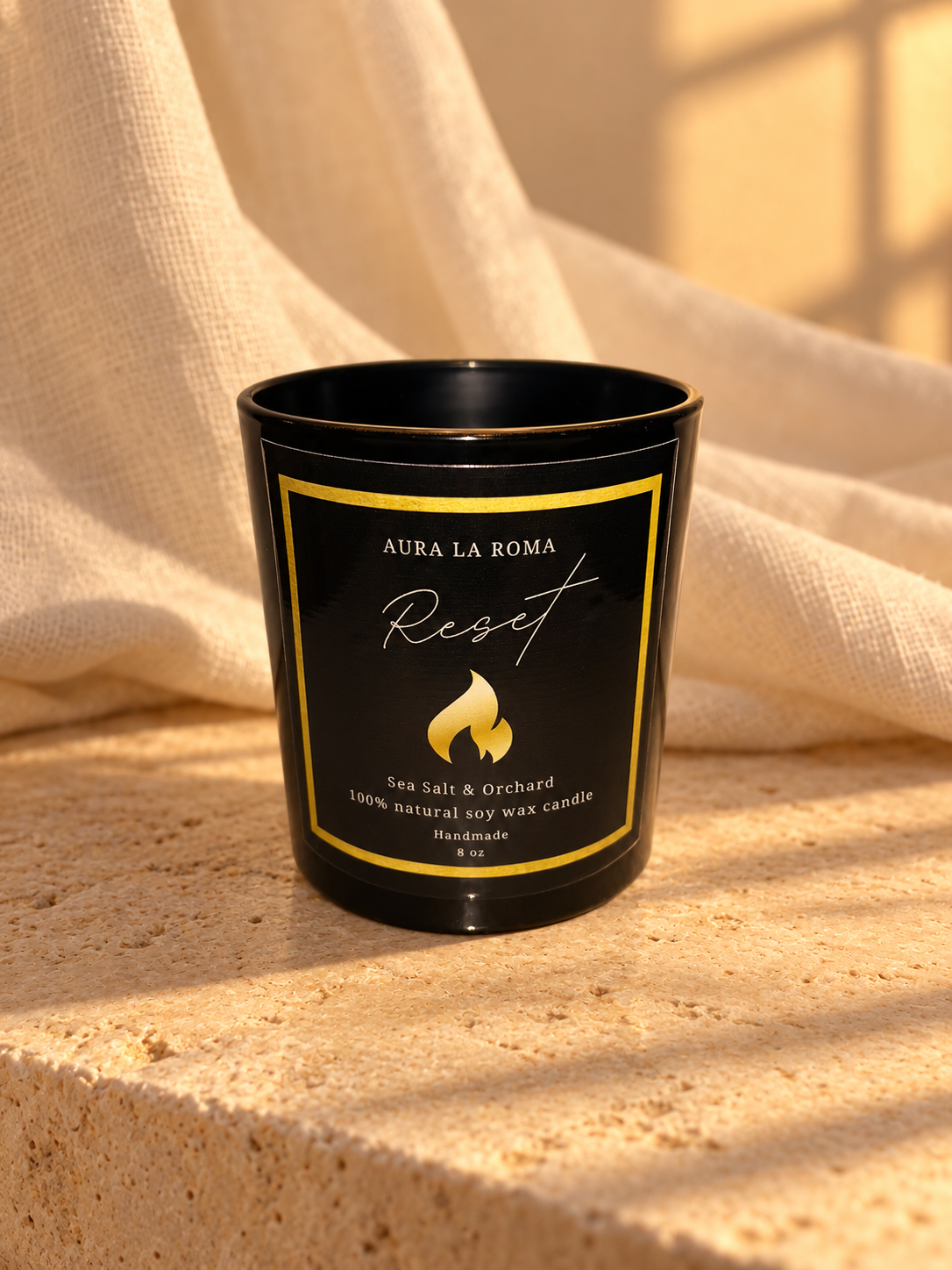 Reset black candle in a quiet ritual setting with natural linen, warm stone and amber evening light.